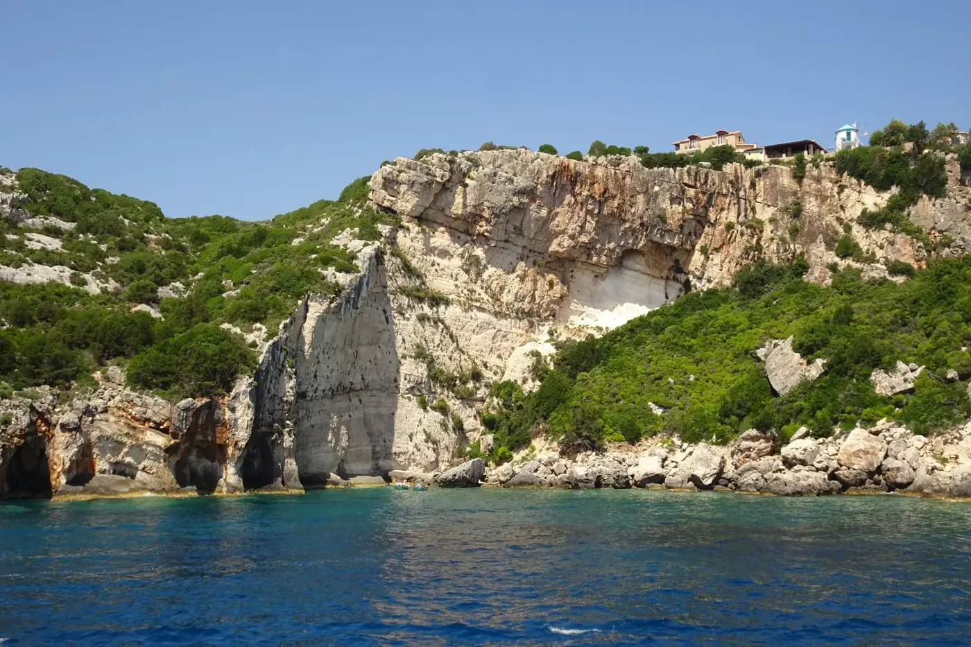 Breathtaking view of a rocky coastline with azure waters under a clear blue sky.