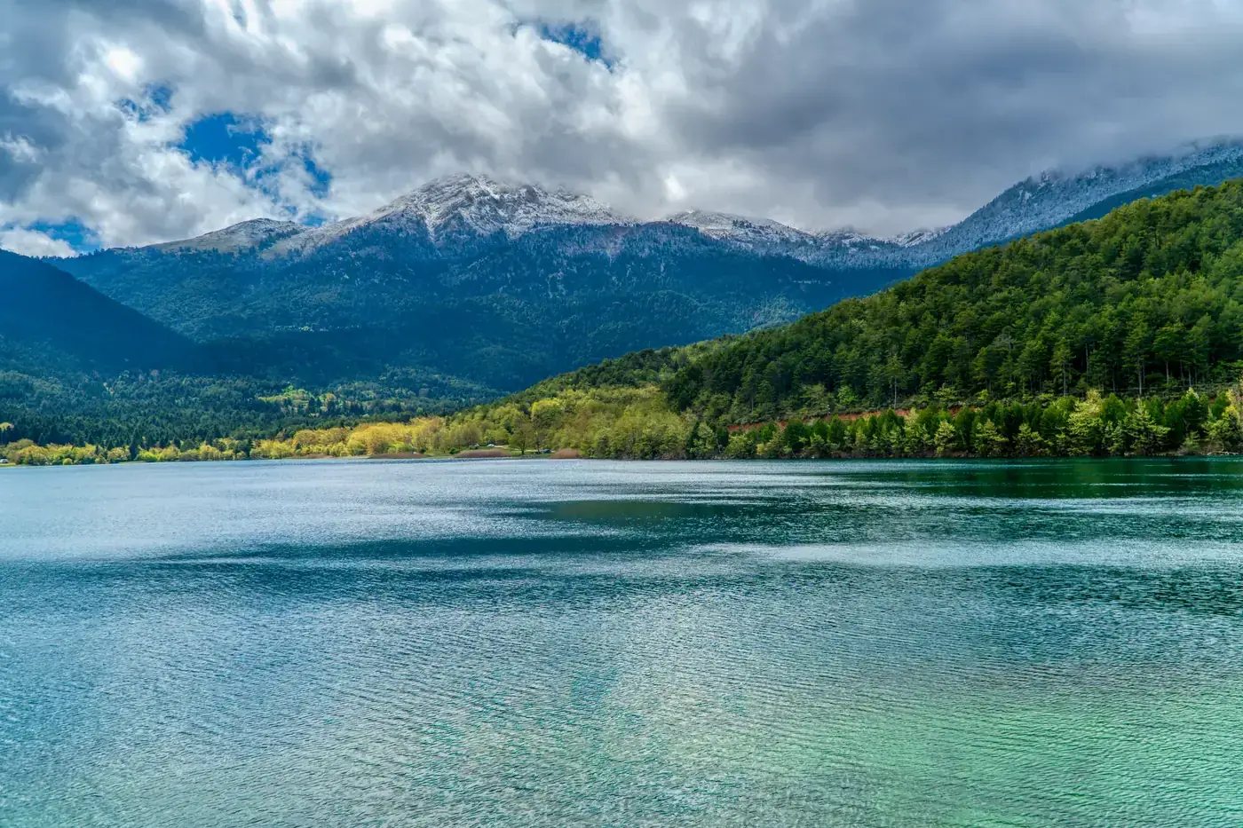 Beautiful landscape of Lake Doxa with majestic snow-capped mountains in Greece.