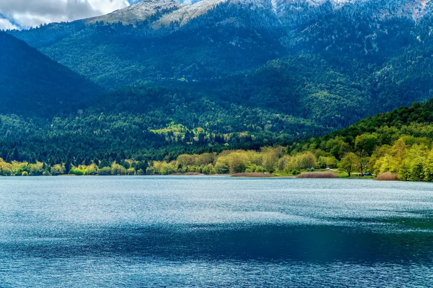 Beautiful view of Lake Doxa surrounded by lush greenery and mountains in Greece.