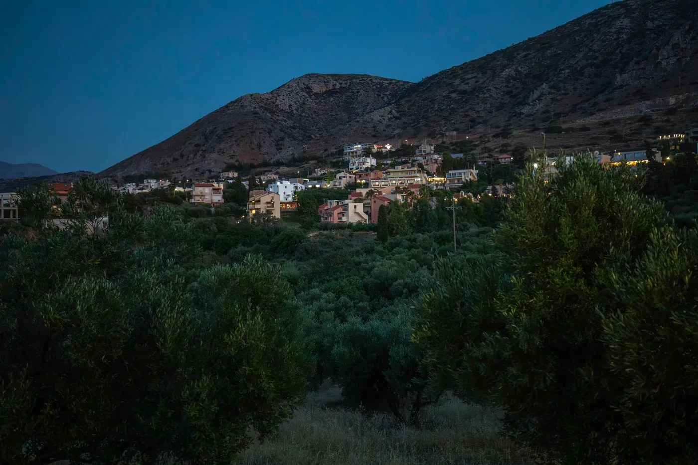 Peaceful twilight view of Hersonissos village surrounded by olive groves and hills in Crete.