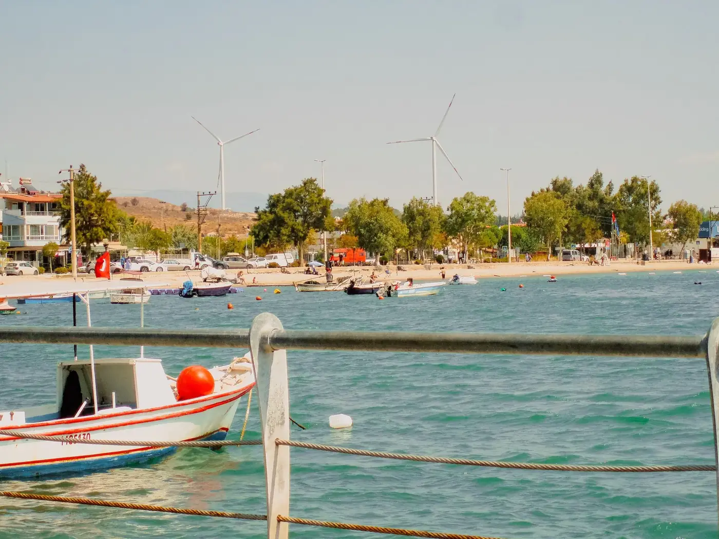 Tranquil seaside view with boats and wind turbines, perfect for relaxation and leisure activities.