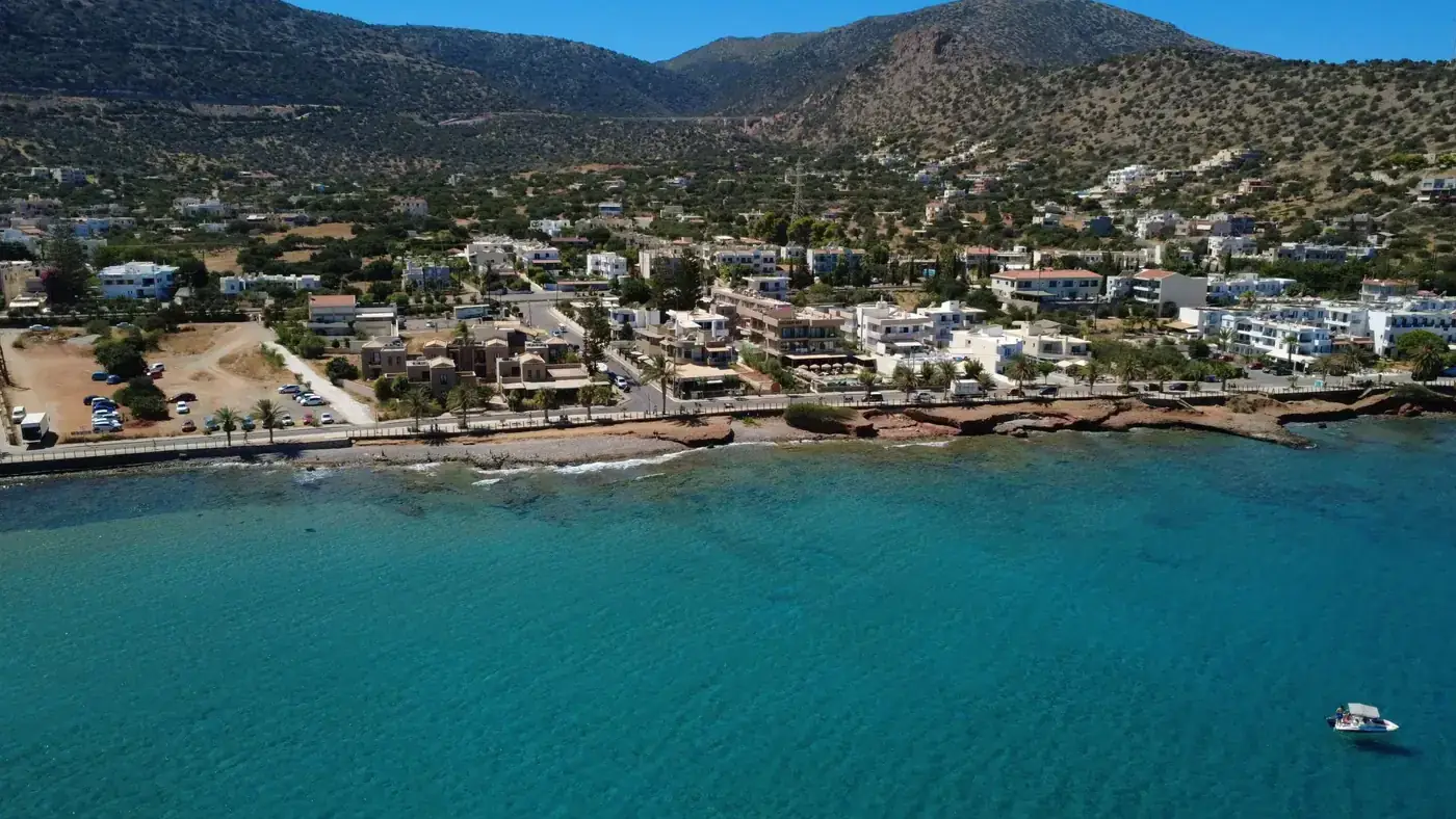 A stunning aerial view of Stalida, Crete showcasing beautiful turquoise waters and coastal architecture under clear skie