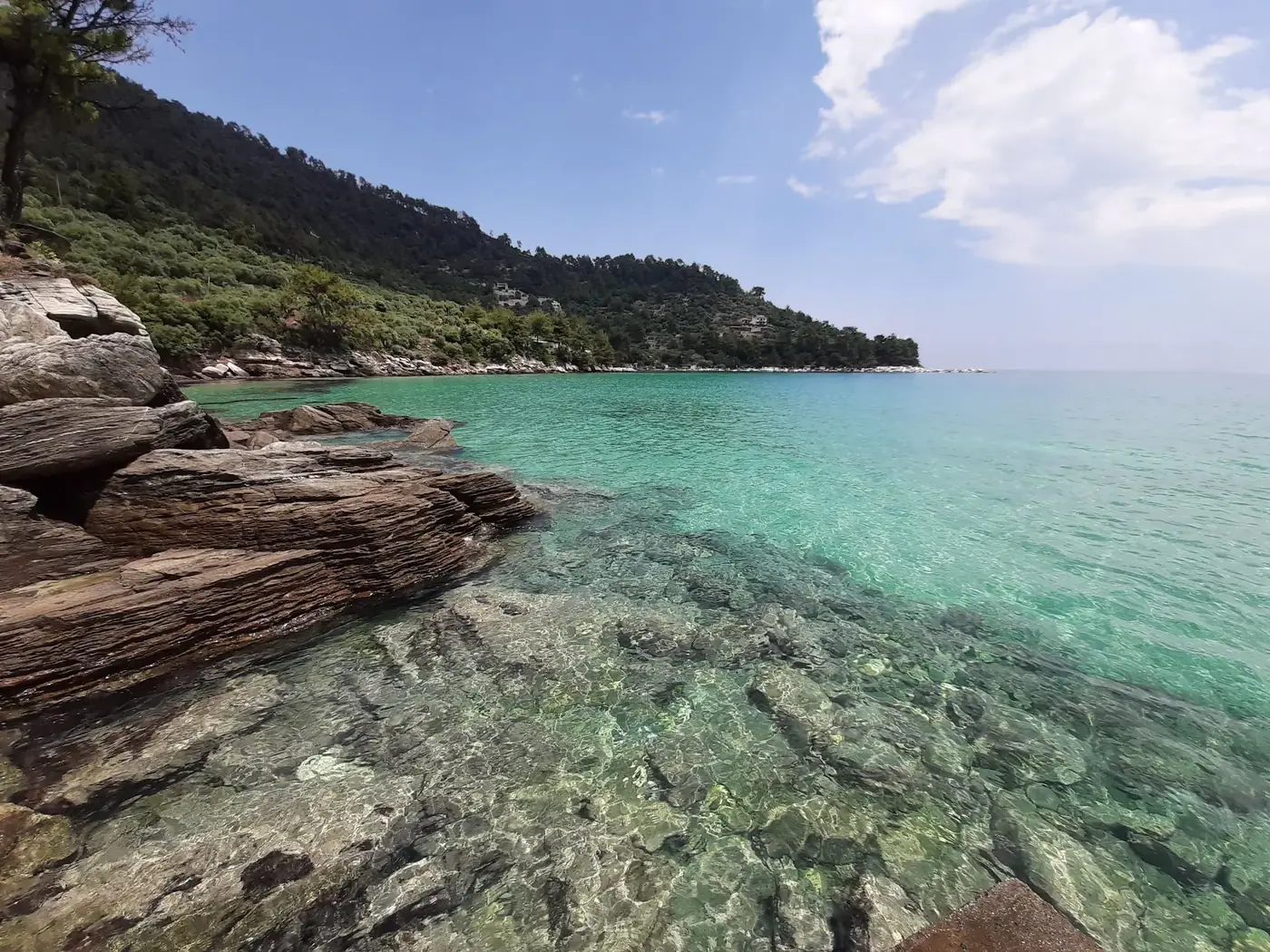 Discover the tranquil beauty of Chrisi Ammoudia's coastline with crystal clear waters and lush greenery.