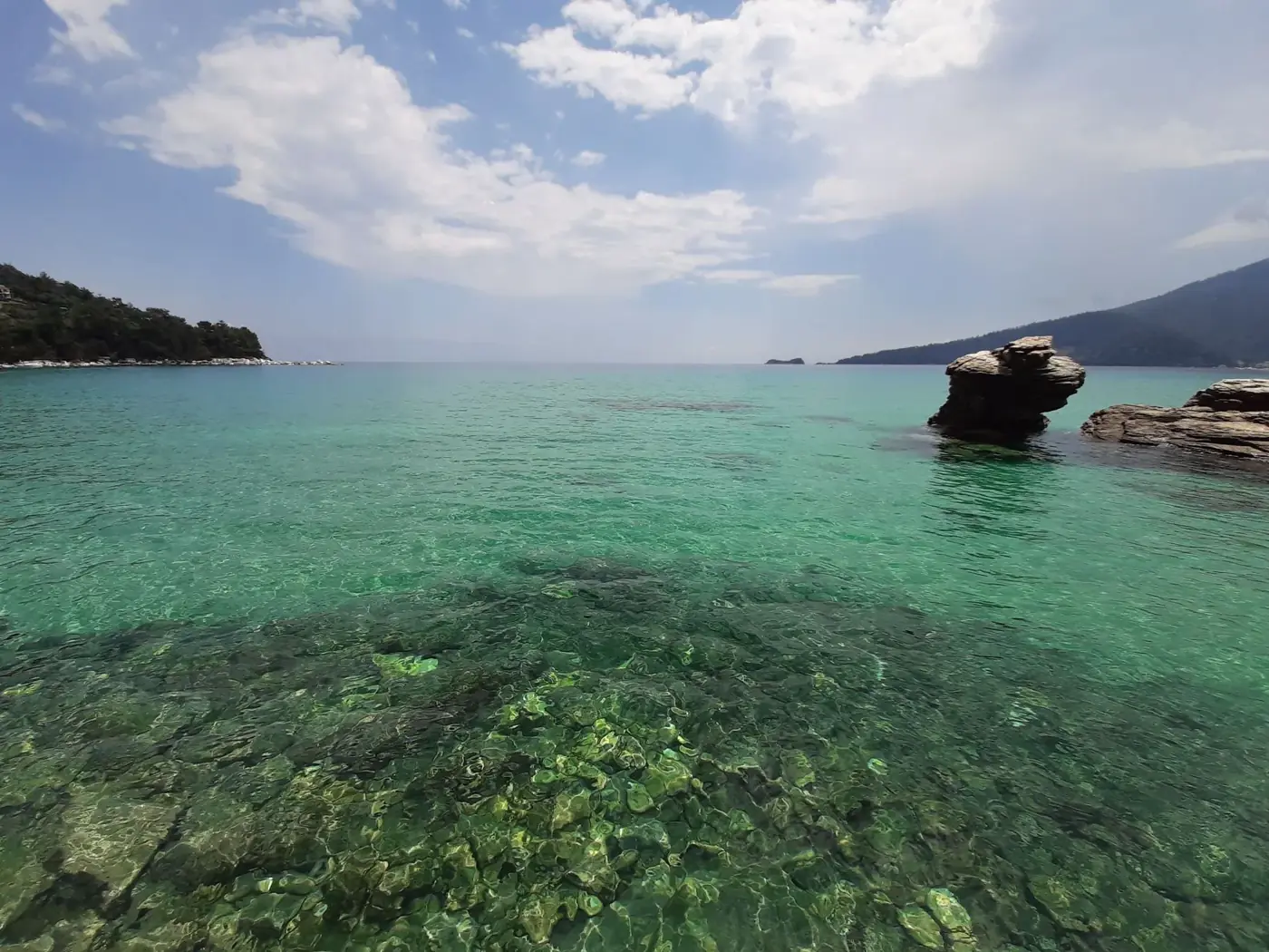 Clear turquoise waters and rocky coastlines at Chrisi Ammoudia, Greece.