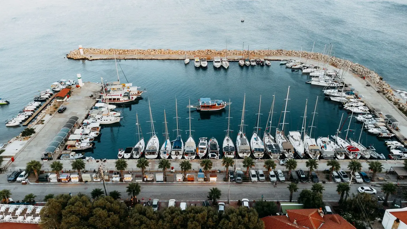 A stunning aerial view of a marina with numerous yachts and boats docked, under a clear blue sky.