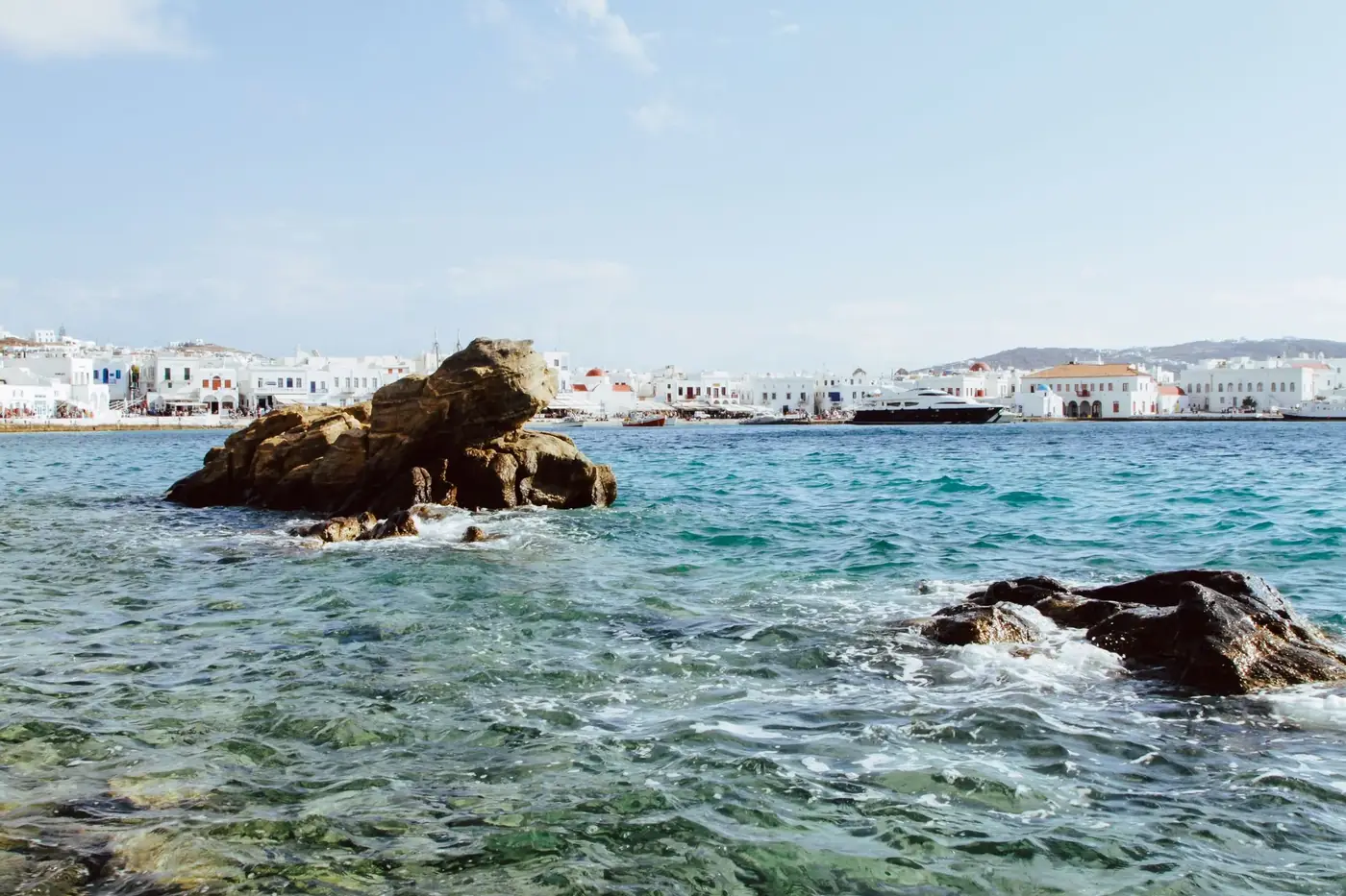 Beautiful coastal scene of Mykonos with rocky shoreline and vibrant blue waters.