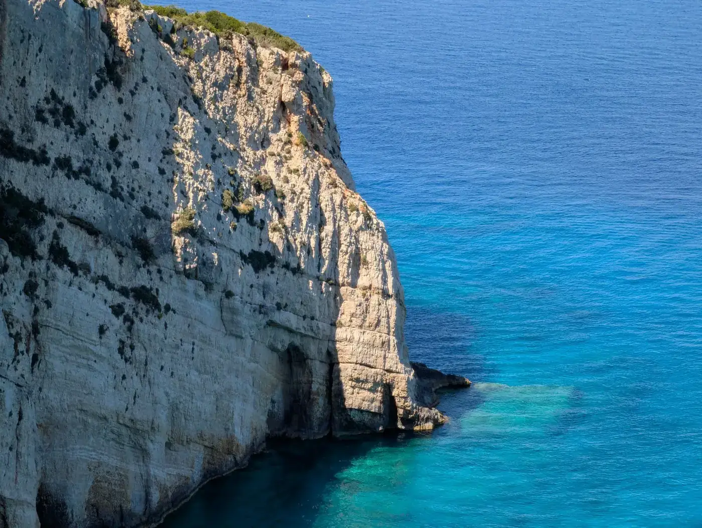 Breathtaking view of a coastal cliff against turquoise sea, embodying natural beauty.
