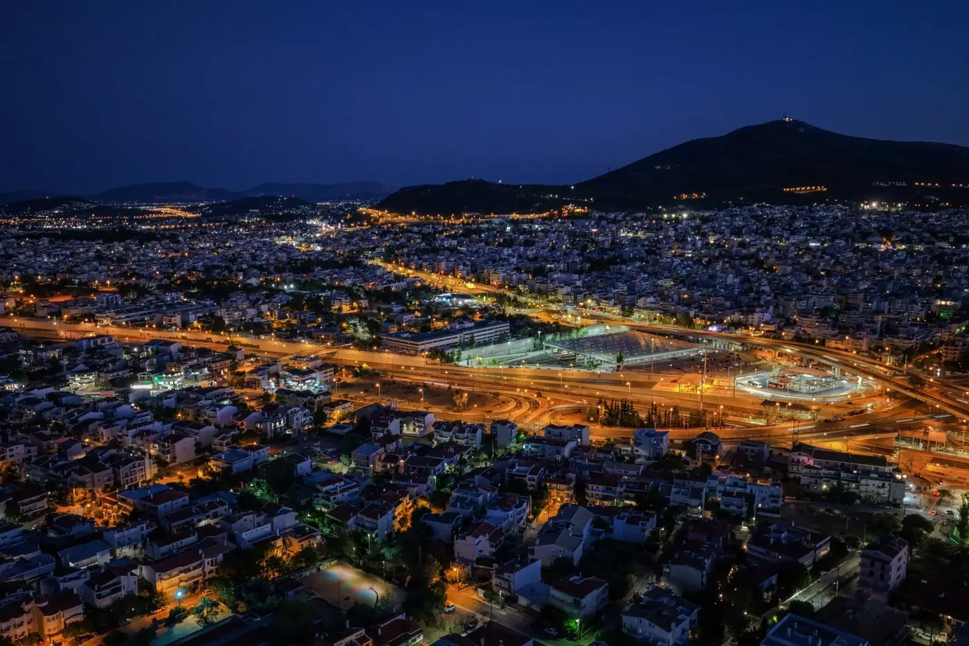 Stunning aerial view of Vrilissia, Greece at night with city lights illuminating the landscape.
