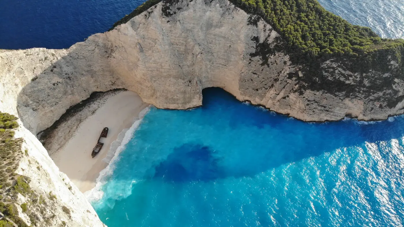 A breathtaking aerial view of Navagio Beach on Zakinthos Island, Greece, featuring vibrant blue waters and a shipwreck.